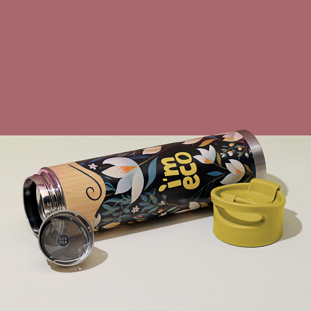 A yellow bamboo water bottle is opened and placed on a white table.