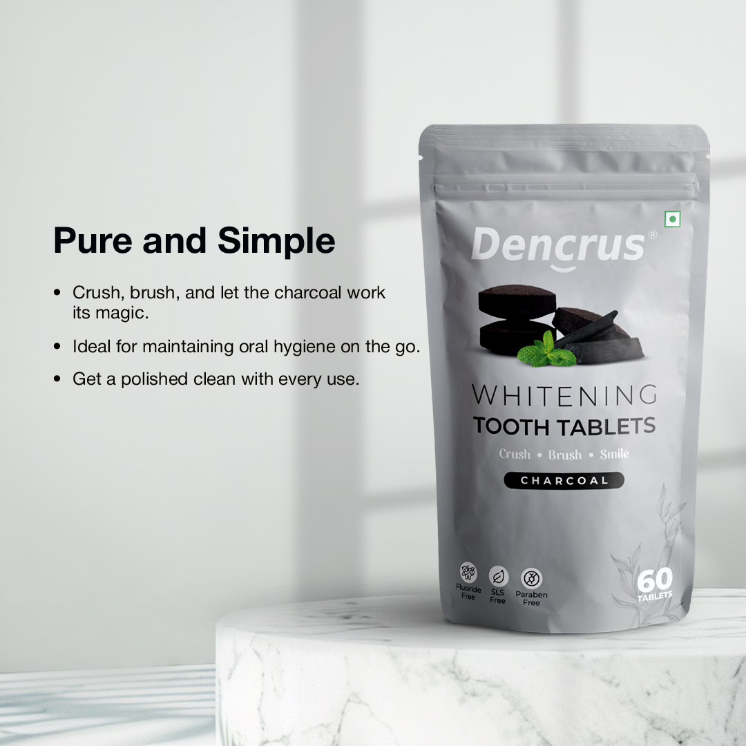 Dencrus whitening tooth tablets with charcoal flavor displayed on a round white stone against a white background