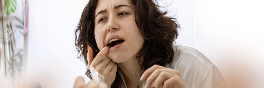 a woman is looking at the mirror for the oral care problems