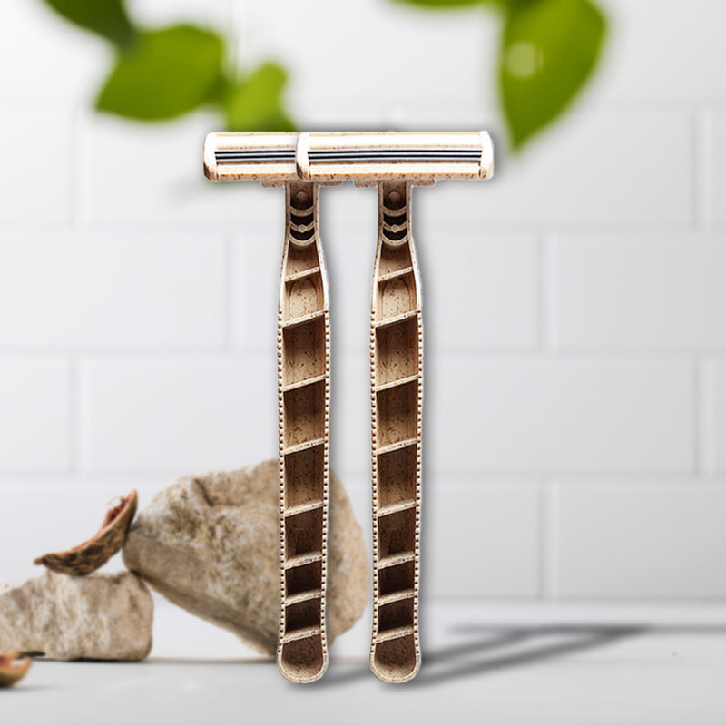 Two Shaveco bamboo husk razors are placed on a light surface with green leaves in the background