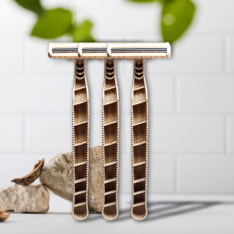 Set of three Shaveco bamboo husk razors on a white background with green leaves in the corner.