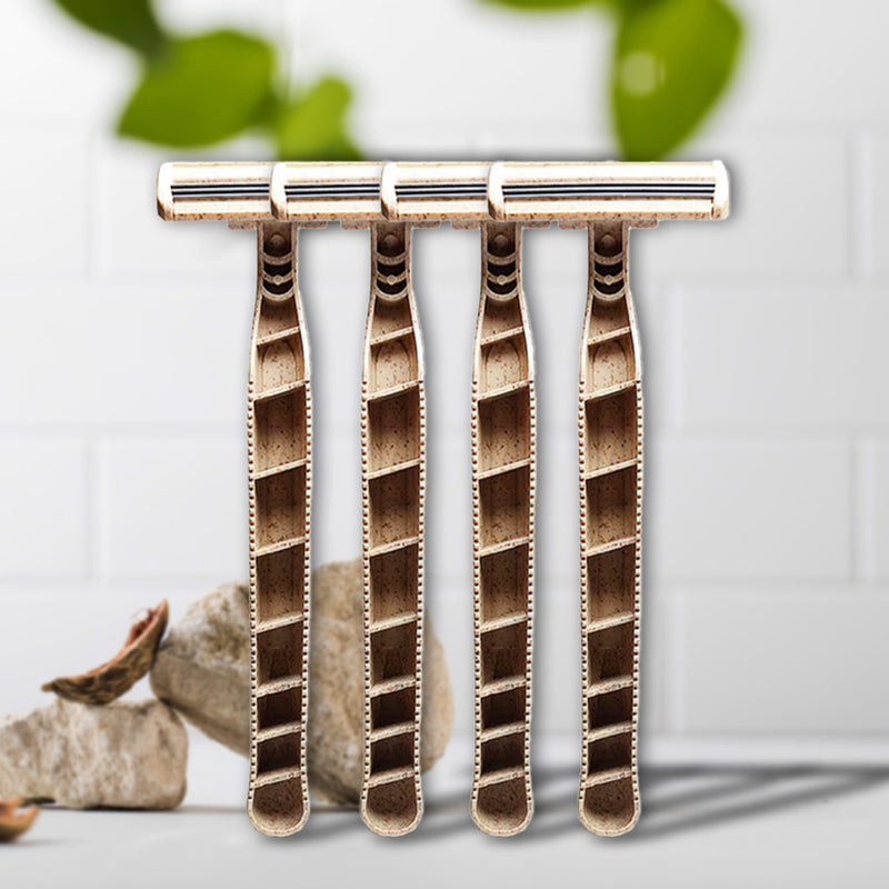 Set of four Shaveco bamboo husk razors on a white background with greenery in the background.