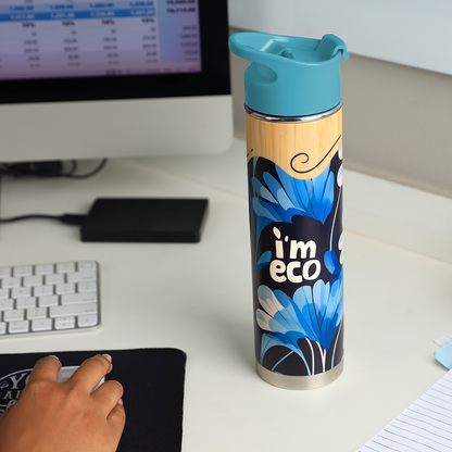 IMECO blue bamboo printed water bottle placed on office desk while a person is working on desktop.