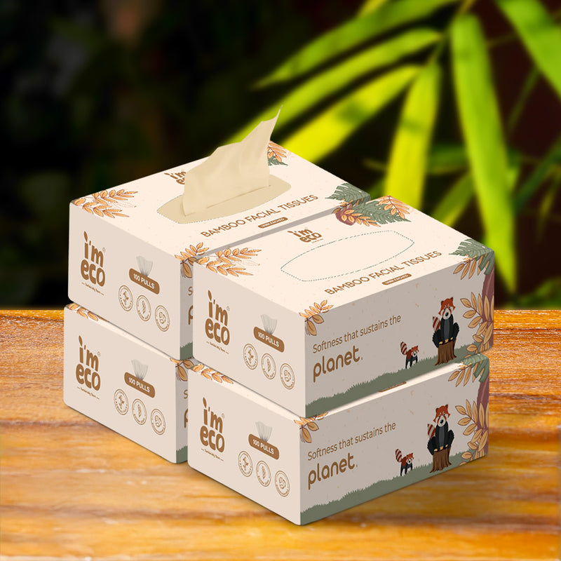 4 boxes of IMECO bamboo facial tissues are kept on a wooden surface with a blurred green leafy background.