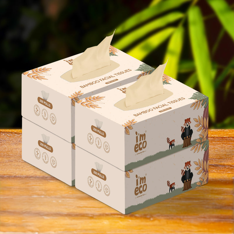 4 boxes of IMECO bamboo facial tissues placed on a wooden surface with a blurred green background.