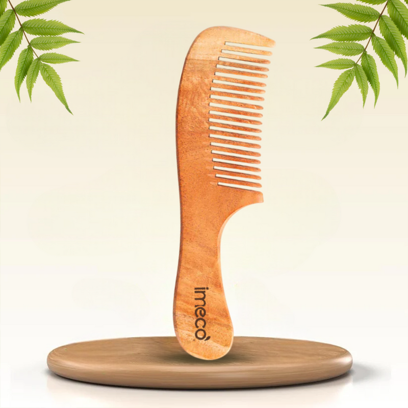 Bamboo comb with IMECO branding on a light background with green leaves.