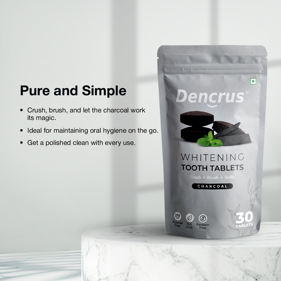 Dencrus whitening tooth tablets with charcoal flavor displayed on a round white round stone against a white background. 
