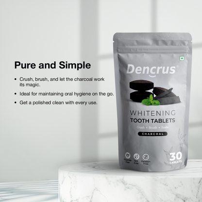 Dencrus whitening tooth tablets with charcoal flavor displayed on a round white round stone against a white background. 