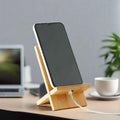An image of IMECO Bamboo Mobile Stand and on it a mobile is being charged against a blurry interior background