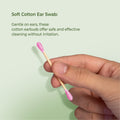 a hand holding a soft cotton ear swab with text on a light green background