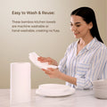 woman holding bamboo kitchen towels with text about ease of washing and reusing.
