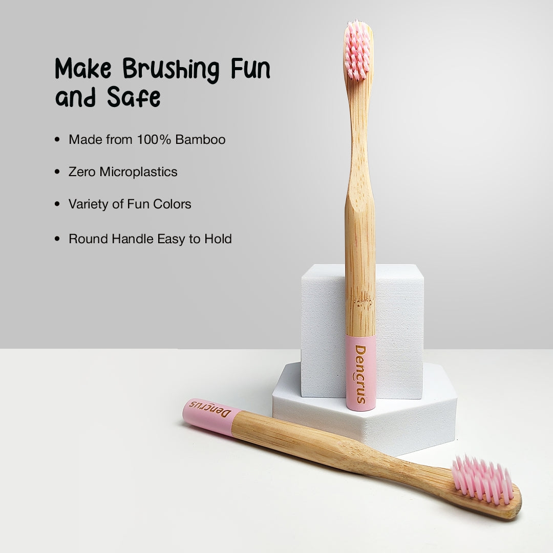 Two ORBY Kids bamboo toothbrushes, one is standing and one is placed on a white surface against a white background highlighting all the key features 