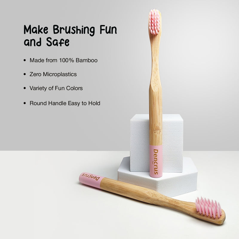 Two ORBY Kids bamboo toothbrushes, one is standing and one is placed on a white surface against a white background highlighting all the key features 