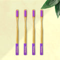 Four ORBY Plus bamboo toothbrushes with lavender-colored bristles and ergonomic handles, displayed on a beige background with a green leaf to the side.